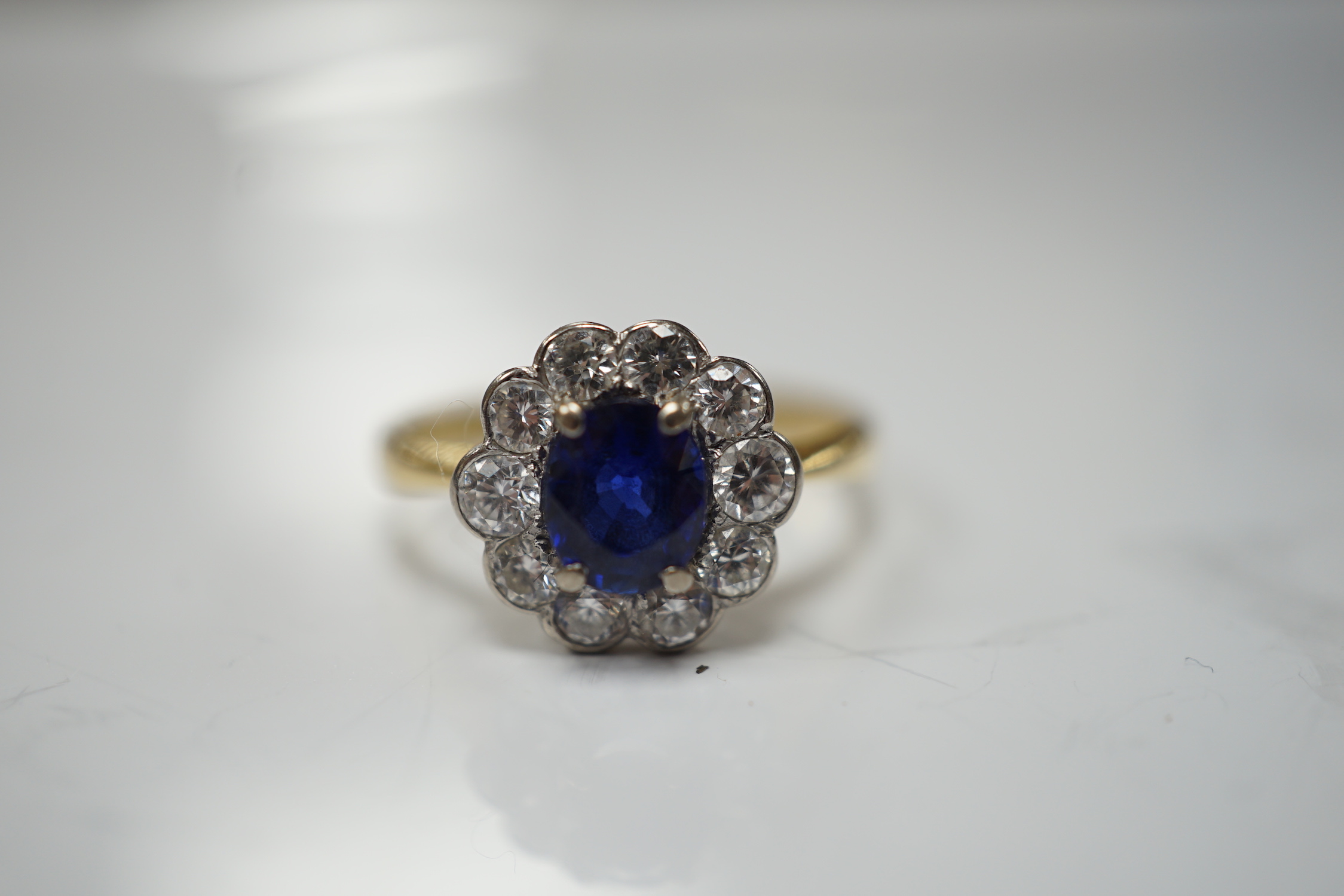 A modern 18ct gold, sapphire and diamond set circular cluster ring, size P/Q, gross weight 3.4 grams.